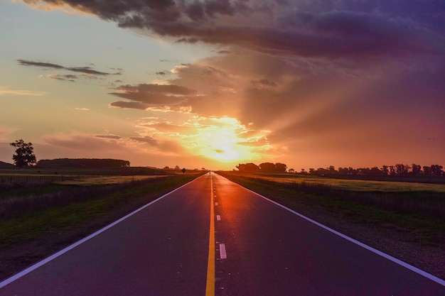 Paesaggio con strada e cielo tempestoso al tramonto