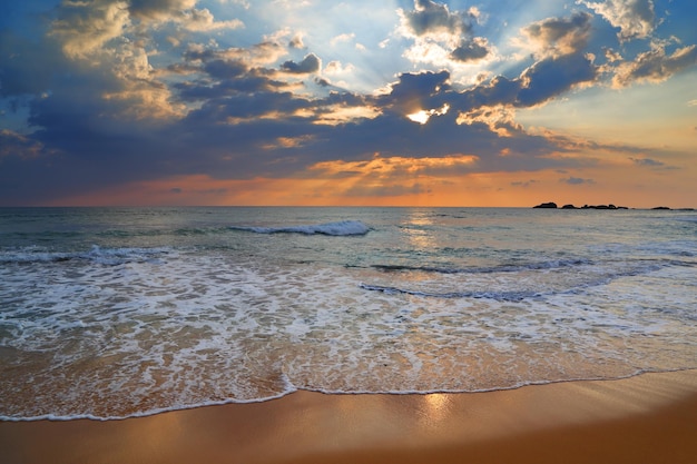 Paesaggio con tramonto sul mare sulla spiaggia