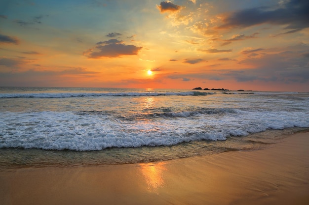 Paesaggio con tramonto sul mare sulla spiaggia