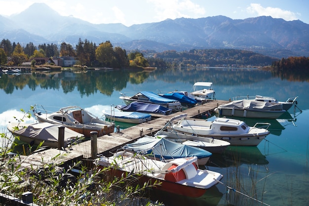 Paesaggio con un bellissimo lago di montagna e barche in primo piano. autunno