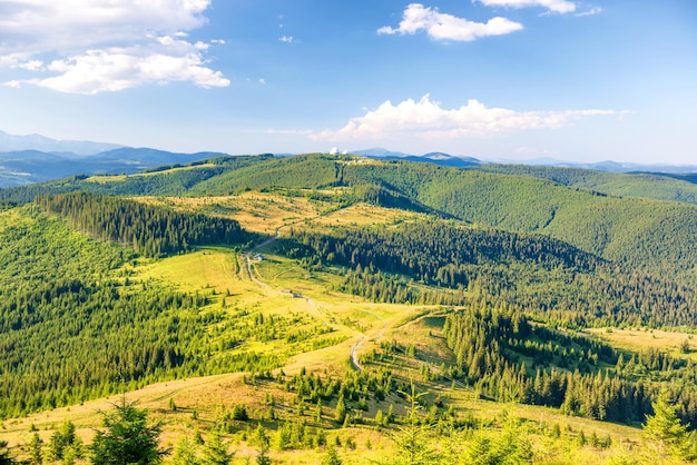 Paesaggio con verdi colline soleggiate con cielo azzurro e nuvole