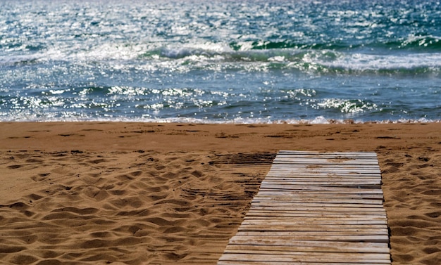 Paesaggio costiero del mare spiaggia sabbiosa e scaletta in legno