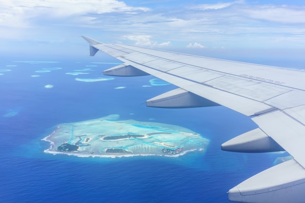 Paesaggio dalla finestra dell'aereo che vede l'ala dell'aereo nuvole bianche cielo blu Isole Maldive