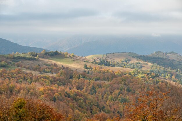 Paesaggio dei Carpazi nelle colline di ottobre e nella catena montuosa in un clima caldo e soleggiato con nuvole basse nel cielo in autunno