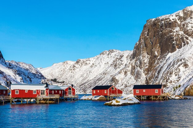 Paesaggio dei Lofoten Cottages circondati da colline rocciose e innevate in Norvegia