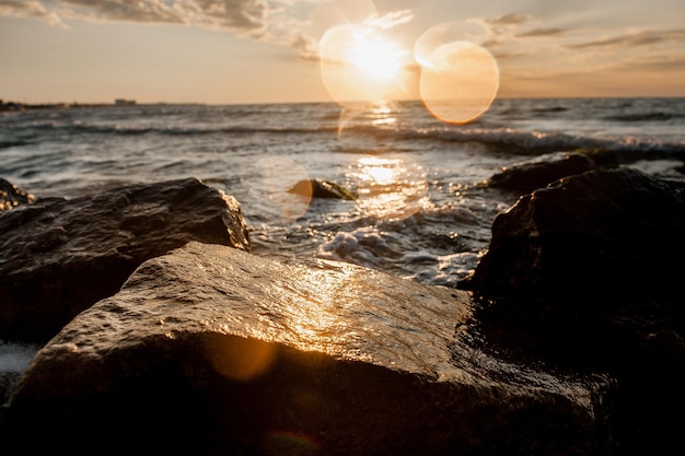 Paesaggio del mare all'alba onde e spruzzi d'acqua al sole