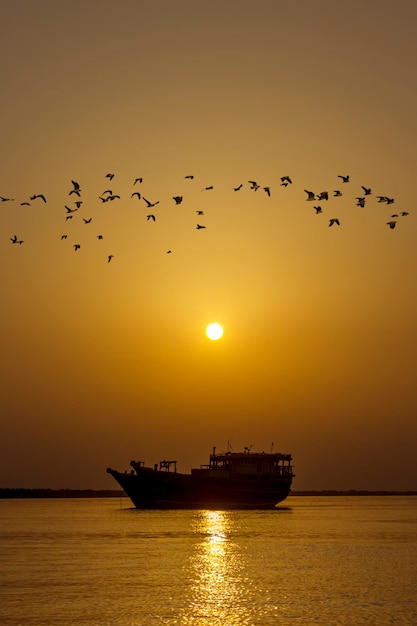 Paesaggio del tramonto con la barca in mare