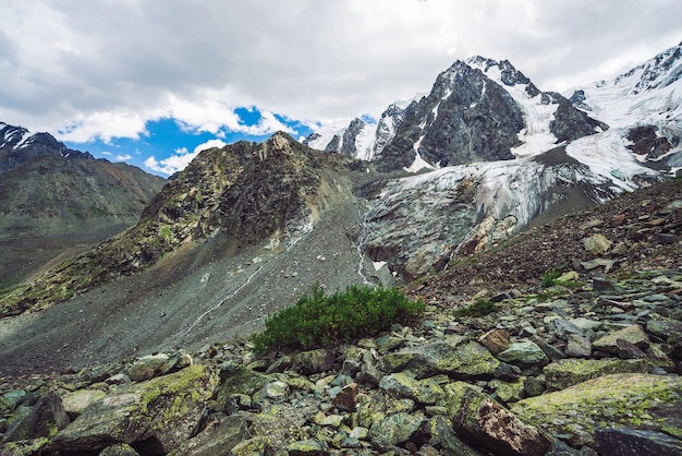 Paesaggio dell'altopiano con grandi montagne innevate e rocce con ghiacciai