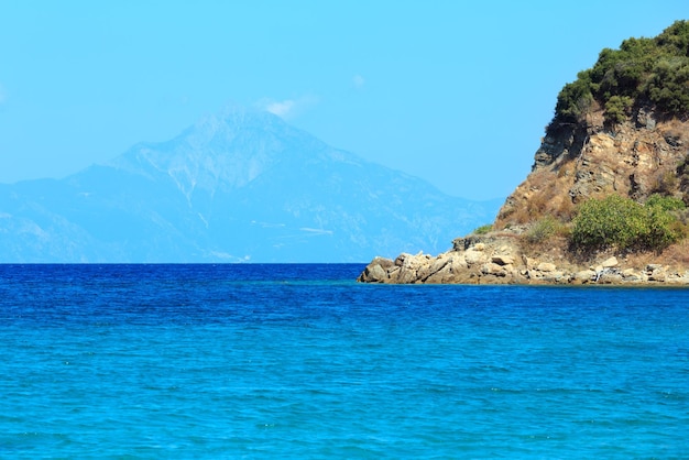 Paesaggio della costa del Mar Egeo con acqua color acquamarina e Monte Athos nella nebbia (Calcidica, Grecia).