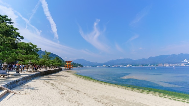 Paesaggio della costa del mare sull'isola di Miyajima che osserva il famoso cancello shintoista giapponese galleggiante arancione (Torii) del santuario di Itsukushima nella baia