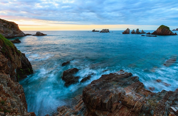 Paesaggio della costa dell'Oceano Atlantico serale. Bella spiaggia di Gueirua con isolotti taglienti. Asturie, Spagna.