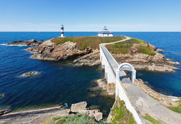 Paesaggio della linea costiera di Pancha dell'isola dell'oceano di estate con il faro (Spagna).