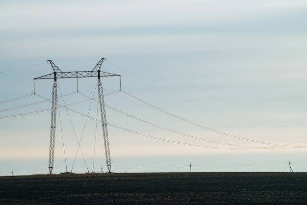 Paesaggio della natura con sagome di linee elettriche in campo