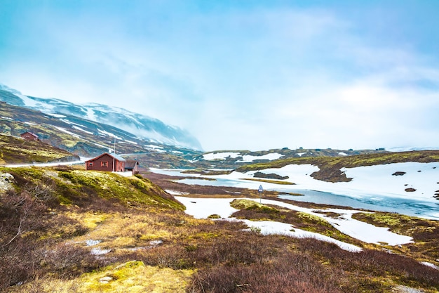 Paesaggio della Norvegia, un piccolo villaggio nella tempesta di neve del tempo inclemente e nebbia nelle montagne. Bella natura Norvegia.