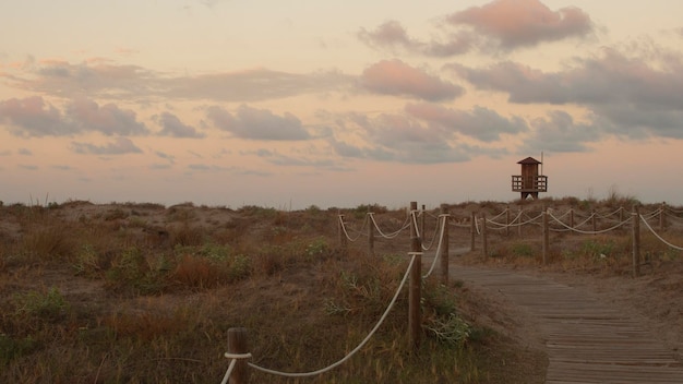 Paesaggio della spiaggia al tramonto con postazione di bagnino in legno sullo sfondo