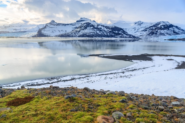 Paesaggio delle catene montuose innevate con la priorità alta verde del muschio