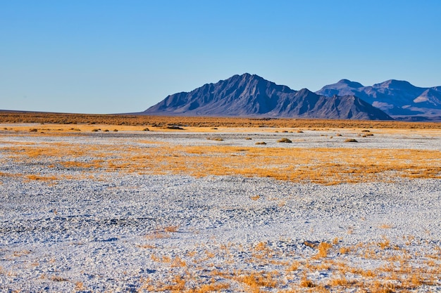 Paesaggio desertico di sabbia bianca che porta alla splendida montagna nera