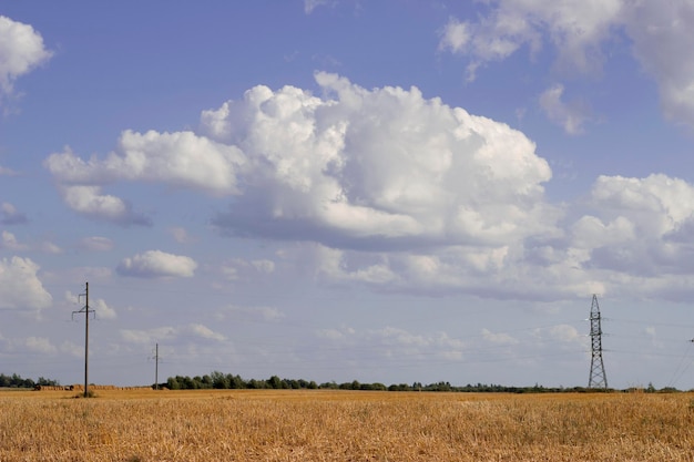paesaggio di campagna estivo con soffici nuvole e campo vuoto dopo la raccolta dei cereali