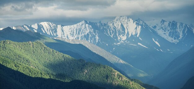 Paesaggio di montagna cime innevate tempo nuvoloso