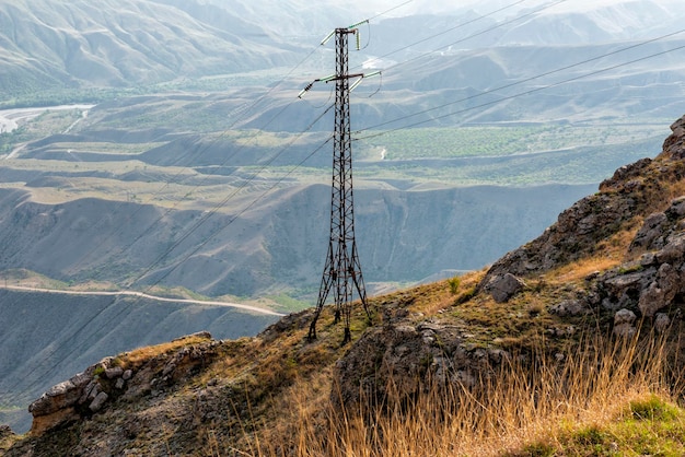 Paesaggio di montagna con albero di linea elettrica ad alta tensione