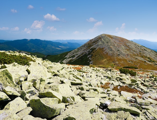 Paesaggio di montagna con pietre sul pendio. Soleggiato clima estivo. Vista sulla vetta della montagna