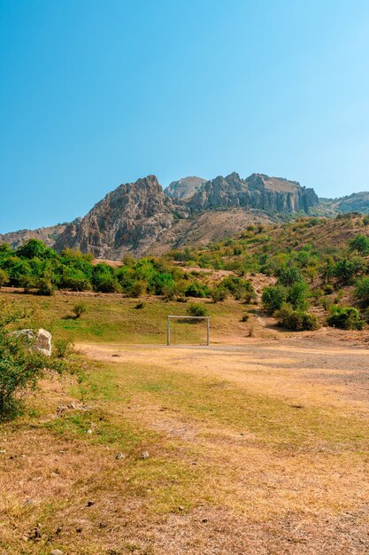 Paesaggio di montagna e una porta da calcio su uno sfondo di cielo blu