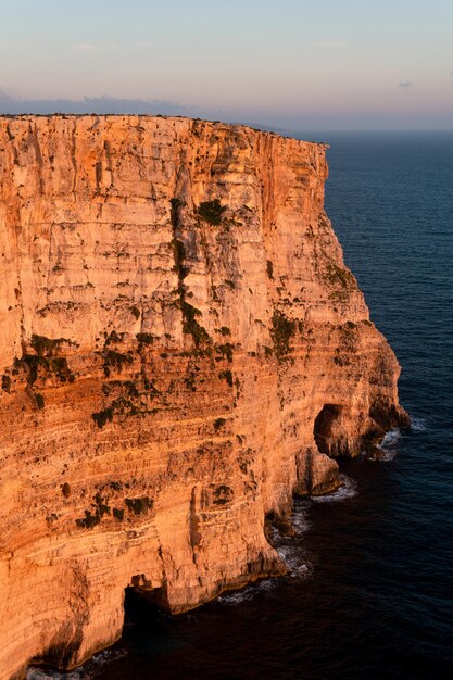 Paesaggio di scogliere con grotte al tramonto