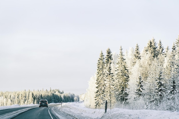 Paesaggio di un'auto su strada in inverno nevoso Lapponia, Rovaniemi, Finlandia