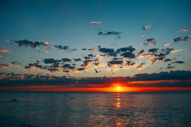 Paesaggio di un'incredibile alba al tramonto sul mare con nuvole drammatiche del cielo