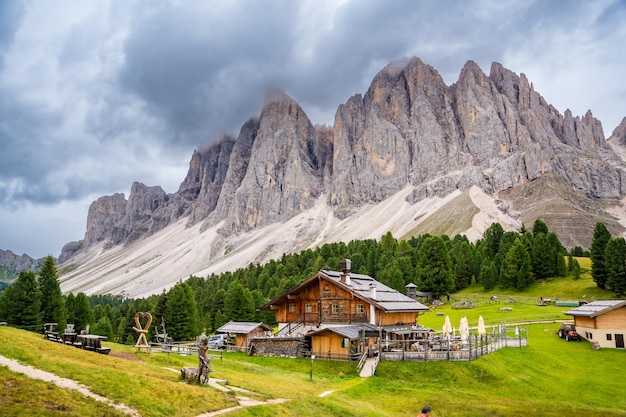 Paesaggio dolomitico nel parco naturale puez odle vista dall'altopiano alpino con case in legno e verde