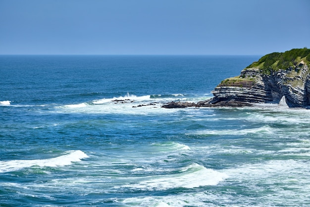 Paesaggio estivo con acqua oceanica e scogliera