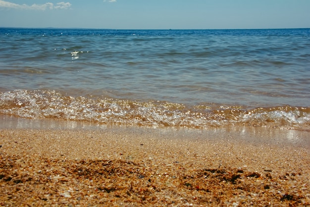 Paesaggio estivo con onde del mare che lambiscono in riva al mare