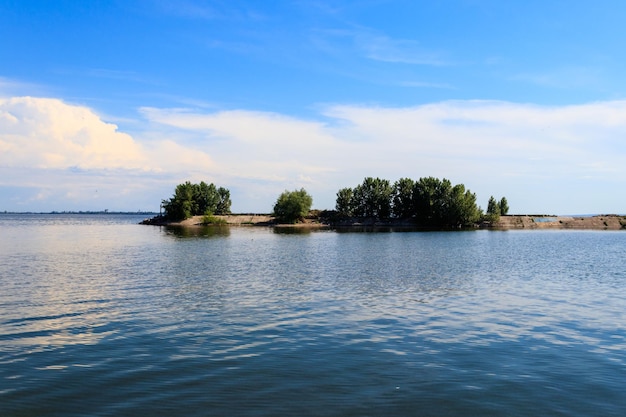 Paesaggio estivo con splendidi alberi verde lago e cielo blu