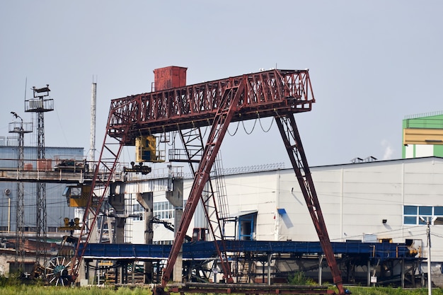 Paesaggio industriale con gru a ponte e a cavalletto in un cantiere di fabbrica