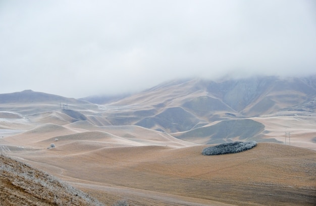 Paesaggio invernale con colline nella nebbia