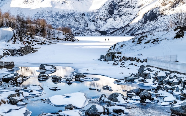 Paesaggio invernale con fiordo semicongelato e montagne coperte di neve nelle isole Lofoten Norvegia