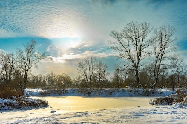 Paesaggio invernale con fiume ghiacciato in una giornata fredda e soleggiata