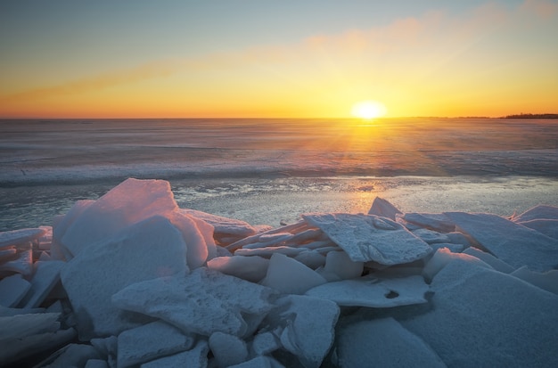 Paesaggio invernale con lago ghiacciato e cielo al tramonto. Composizione della natura.