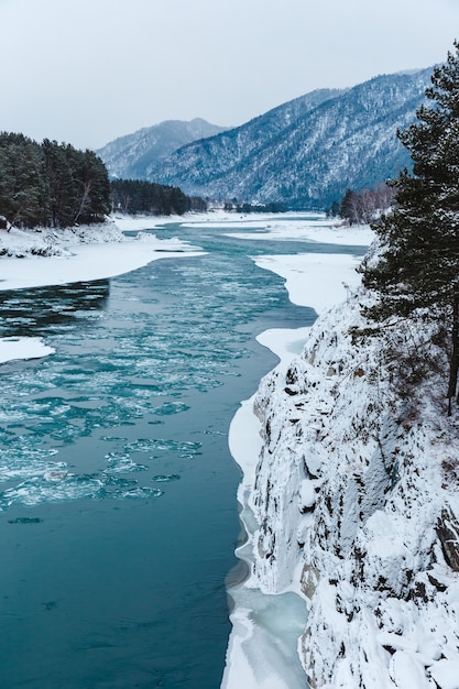 Paesaggio invernale con rocce, pietre e ghiaccio nel fiume in montagna