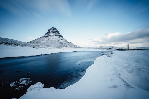 Paesaggio invernale con sole nascente sulla cascata di Kirkjufellsfoss e sulla montagna di Kirkjufell Islanda Europa