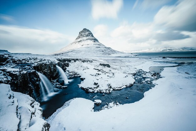 Paesaggio invernale con sole nascente sulla cascata Kirkjufellsfoss e sulla montagna di Kirkjufell Islanda Europa