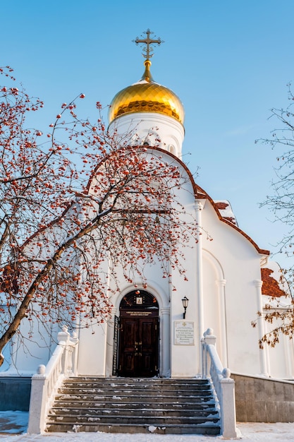 Paesaggio invernale con una chiesa ortodossa con cupole dorate in una soleggiata giornata invernale Togliatti Russia