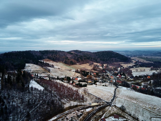 Paesaggio invernale con villaggio vicino alle montagne