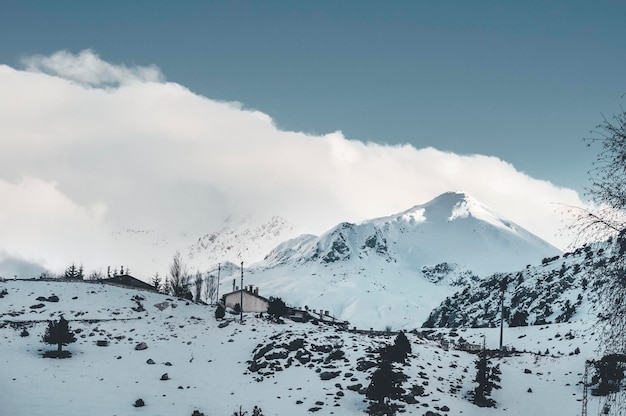 Paesaggio invernale di montagna innevata con nuvole. Scena di neve pittoresca e meravigliosa.
