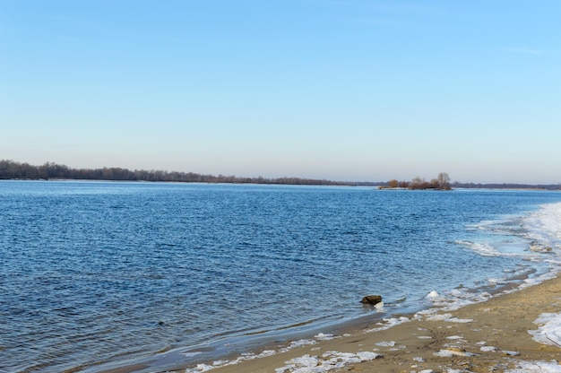 Paesaggio invernale Una veduta dell'ampio fiume Su una riva deserta Pezzi di ghiaccio Stagione fredda