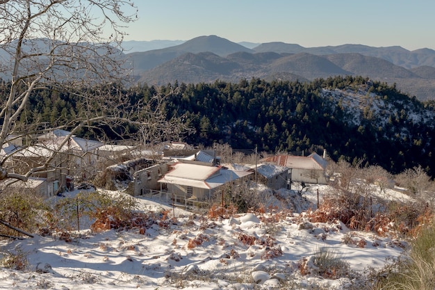 Paesaggio invernale Vista di un piccolo villaggio di alta montagna e montagne in una soleggiata giornata invernale Regione della Grecia Arcadia