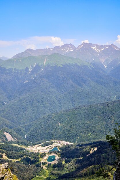 Paesaggio luminoso di montagna con montagne innevate, cielo azzurro e nuvole Montagna