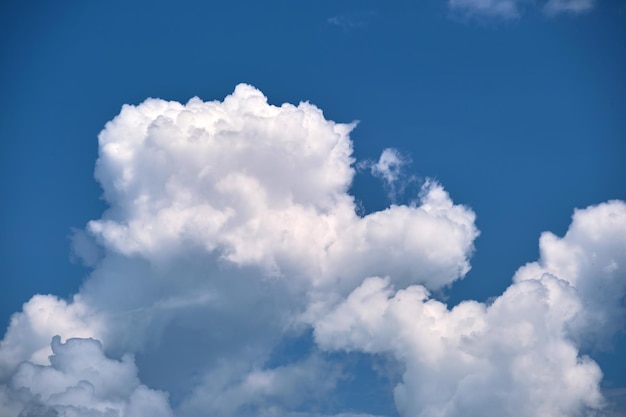 Paesaggio luminoso di nuvole cumuliformi gonfie bianche su cielo blu chiaro.