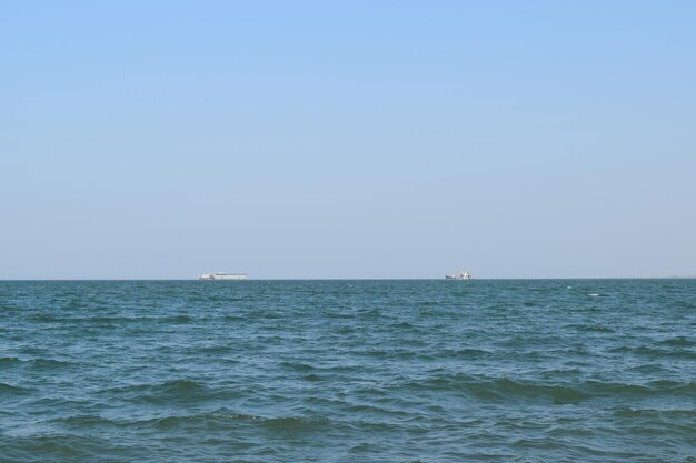 Paesaggio marino e due navi all'orizzonte Giorno marino e piccole onde