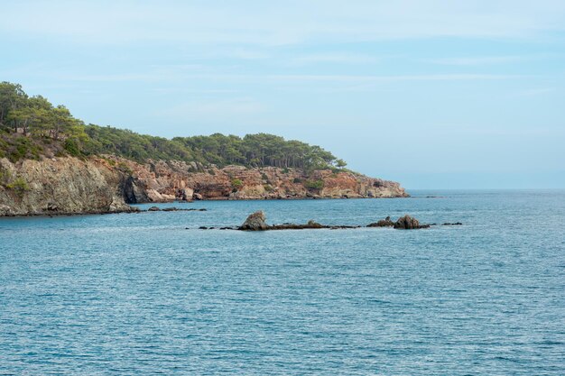 Paesaggio marino mediterraneo con ripide coste boscose e scogliere